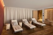 Heller Ruheraum im Familienhotel Bella Vista in Südtirol mit Liegen, Holzboden und warmem Licht.