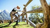 Wandern im Salzburger Land: Mann repariert den Zaun auf der Abergalm in der Nähe von Saalfelden.