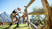 Wandern im Salzburger Land: Mann repariert den Zaun auf der Abergalm in der Nähe von Saalfelden.