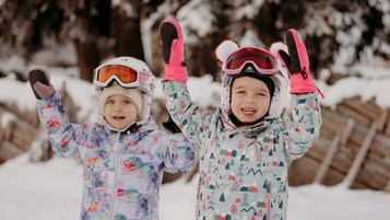 Zwei Mädchen die sich auf Ski fahren freuen.