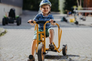 Ein Kind fährt auf dem Gelände des Kinderhotels Bruckwirt in Oberösterreich mit einem Go-Kart.