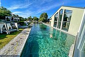 Außenansicht des Outdoor-Schwimmbecken mit wunderschönen Liegemöglichkeiten im Familienhotel Ulrichshof im Bayerischen Wald