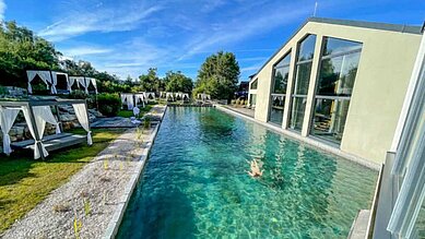 Außenansicht des Outdoor-Schwimmbecken mit wunderschönen Liegemöglichkeiten im Familienhotel Ulrichshof im Bayerischen Wald