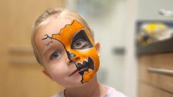Ein Junge mit einem teilweise für Halloween geschminktem Gesicht