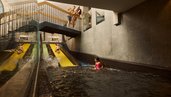 Familie mit zwei Kindern rutscht auf den Wasserrutschen im Schwimmbad des Familienhotels Alpenhotel Kindl ins Becken.