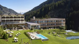 Außenansicht des Familienhotels Bella Vista mit modernem Neubau, Außenpool, Spielplatz und herrlicher Bergkulisse.