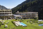 Außenansicht des Familienhotels Bella Vista mit modernem Neubau, Außenpool, Spielplatz und herrlicher Bergkulisse.