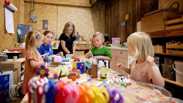 Drei Kinder basteln und werken in der Kreativwerkstatt für Kinder im Familienhotel Habachklause im Salzburger Land.