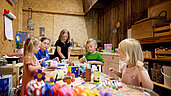 Drei Kinder basteln und werken in der Kreativwerkstatt für Kinder im Familienhotel Habachklause im Salzburger Land.