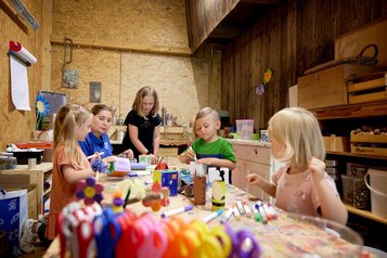 Drei Kinder basteln und werken in der Kreativwerkstatt für Kinder im Familienhotel Habachklause im Salzburger Land.