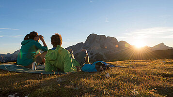 Kurze Verschnaufspause beim Wandern am Berg und den Sonnenuntergang genießen. Die Aussicht in Südtirol ist spitze.