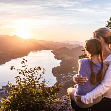 Wandern im Salzburger Land: Mutter und Tochter betrachten den Sonnenuntergang Arm in Arm auf dem Aussichtspunkt Ellmaustein