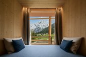 Gemütliche Sitzecke am Fenster im Hotel Bella Vista in Südtirol mit Blick auf die Berge und die Natur.