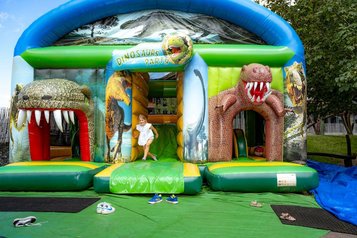 Kind spielt auf einer bunten Hüpfburg mit Dinosaurier-Motiven im Familienhotel Krone im Allgäu.
