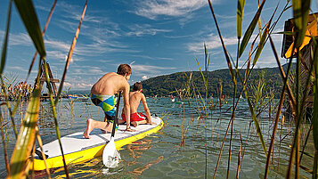 Zwei Jungs auf einem SUP im Sommer auf dem See.