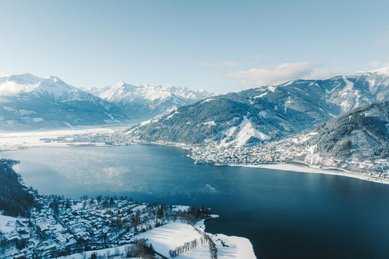 Winterliche Landschaft am Zeller See mit verschneiten Bergen nahe dem Familienhotel Amiamo im Salzburger Land.