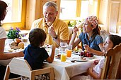 Glückliche Familie beim Frühstücken im Familienhotel Engel im Hochschwarzwald. Das reichhaltige Frühstücksbuffet ist in der All-Inclusive Verpflegung inbegriffen.