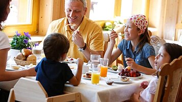 Glückliche Familie beim Frühstücken im Familienhotel Engel im Hochschwarzwald. Das reichhaltige Frühstücksbuffet ist in der All-Inclusive Verpflegung inbegriffen.