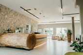 Stilvolle Rezeption mit Baumstammtheke im Familienhotel Friedrichshof.