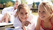 Zwei Mädchen liegen am Pool des Familienhotels Sonnenpark im Sauerland.