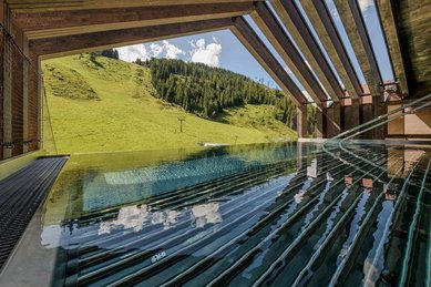 Der Poolbereich des Zauchenseehofs im Salzburger Land bietet einen freien Blick auf die grüne Hanglandschaft.