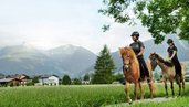 Reiterinnen und Reiter sind nahe dem Hotel Sonngastein im Salzburger Land im Gasteinertal unterwegs.