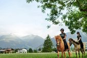 Reiterinnen und Reiter sind nahe dem Hotel Sonngastein im Salzburger Land im Gasteinertal unterwegs.