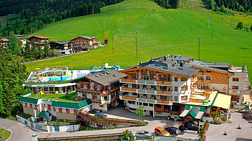 Luftaufnahme mit Landschaft vom Wellness- & Familienhotel Egger in Saalbach Hinterglemm.