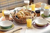Gedeckter Tisch zum Frühstück mit Semmeln, Orangensaft und vielem mehr im Kinderhotel Bruckwirt in Oberösterreich.