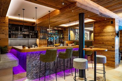 Gemütliche Bar mit Barhockern im Familienhotel Adler Familien- & Wohlfühlhotel in Tirol.