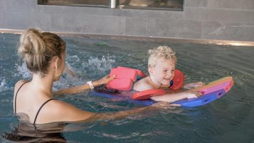 Mutter und Kind schwimmen gemeinsam im Pool des Familienhotels Gorfion