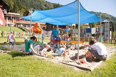 Im Familienhotel Ramsi lädt ein großer, beschatteter Sandspielplatz mit bunter Kulisse und zahlreichen Spielmöglichkeiten zum fröhlichen Buddeln und Toben ein