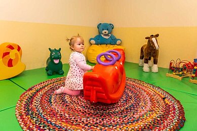 Kleines Mädchen spielt im Happy-Club mit Spielsachen für kleine Kinder im Familienhotel Landhaus zur Ohe im Bayerischen Wald.