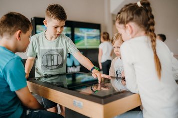 Kinder entdecken die interaktive Spielecke im Familienhotel Friedrichshof mit Begeisterung.