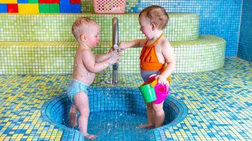 Babys im Babyschwimmbecken mit Wasserspielsachen im Familienhotel Elldus Resort im Erzgebirge