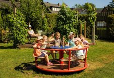 Kinder sitzen in einem Karussell.
