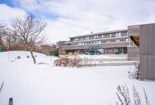 Das Familienhotel Strandkind an der Ostsee in einer verschneiten Umgebung.