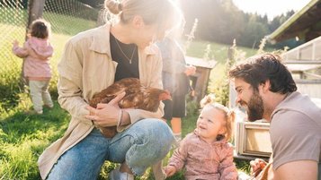 Familie mit Kleinkindern beim Besuch der Kleintiere im Familienhotel Das Bayrischzell