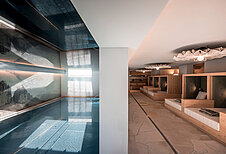 Moderner Indoor-Pool mit anschließenden Ruheliegen im Familienhotel Alpenhof Dolomit Family