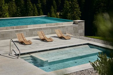 Beheizter Outdoor-Infinity-Panoramapool und Freiluft-Whirlpool mit Liegen und Bergblick im Hotel Bella Vista in Südtirol.