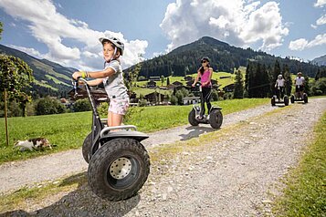 Kinder beim Segway fahren beim Familienurlaub im Galtenberg Family & Wellness Resort in Tirol.