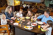 Familie speist im Restaurant mit Tischgrill im Familienhotel Feldberger Hof.