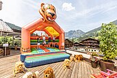 Kinder hüpfen auf der großen Hüpfburg vom Familienhotel Galtenberg Family & Wellness Resort in Tirol.