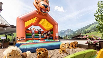 Kinder hüpfen auf der großen Hüpfburg vom Familienhotel Galtenberg Family & Wellness Resort in Tirol.