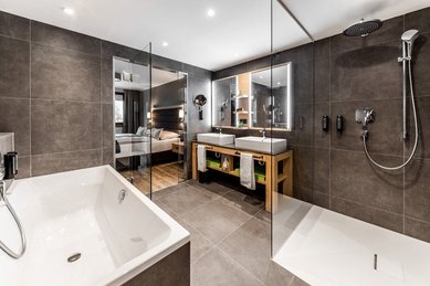 Modernes Badezimmer mit Dusche, Badewanne und Doppelwaschtisch im Familienhotel Das Bayrischzell