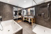 Modernes Badezimmer mit Dusche, Badewanne und Doppelwaschtisch im Familienhotel Das Bayrischzell