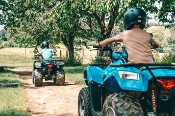 Kinder drehen mit ihren Quads rasante Runden auf dem Gelände vom Familienhotel Friedrichshof.