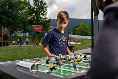 Zwei Jungs spielen im Teens-Club des Familienhotels Elldus Resort gemeinsam Tischkicker.