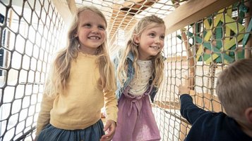 Zwei Mädchen spielen auf dem Indoor-Spielplatz im Familienhotel