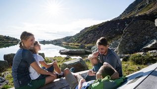 Familie genießt die Aussicht auf den See und auf die Berge im Familienurlaub in Südtirol.